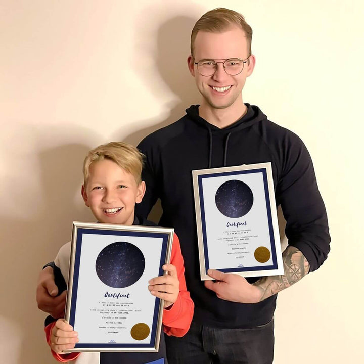 Un homme et un garçon souriants tiennent chacun un certificat d’étoile.